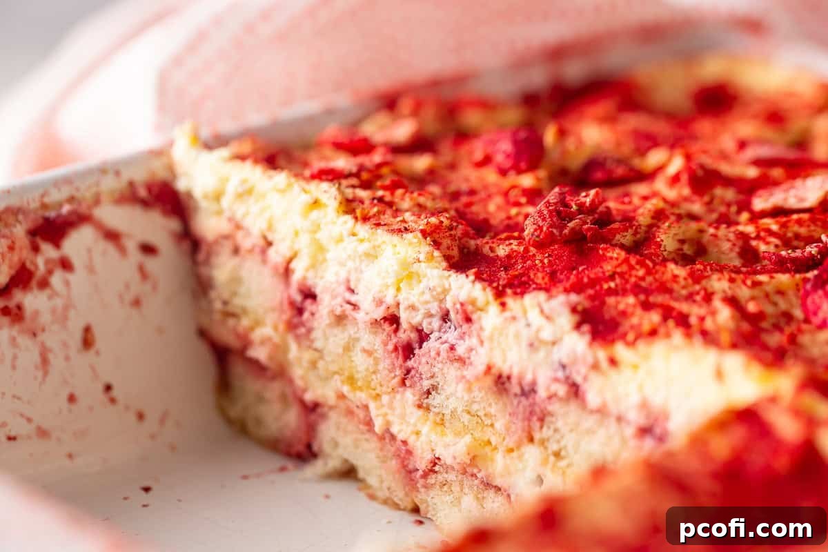 Strawberry Tiramisu Recipe with Mascarpone and Ladyfingers 3 A pan of strawberry tiramisu with a slice taken out.