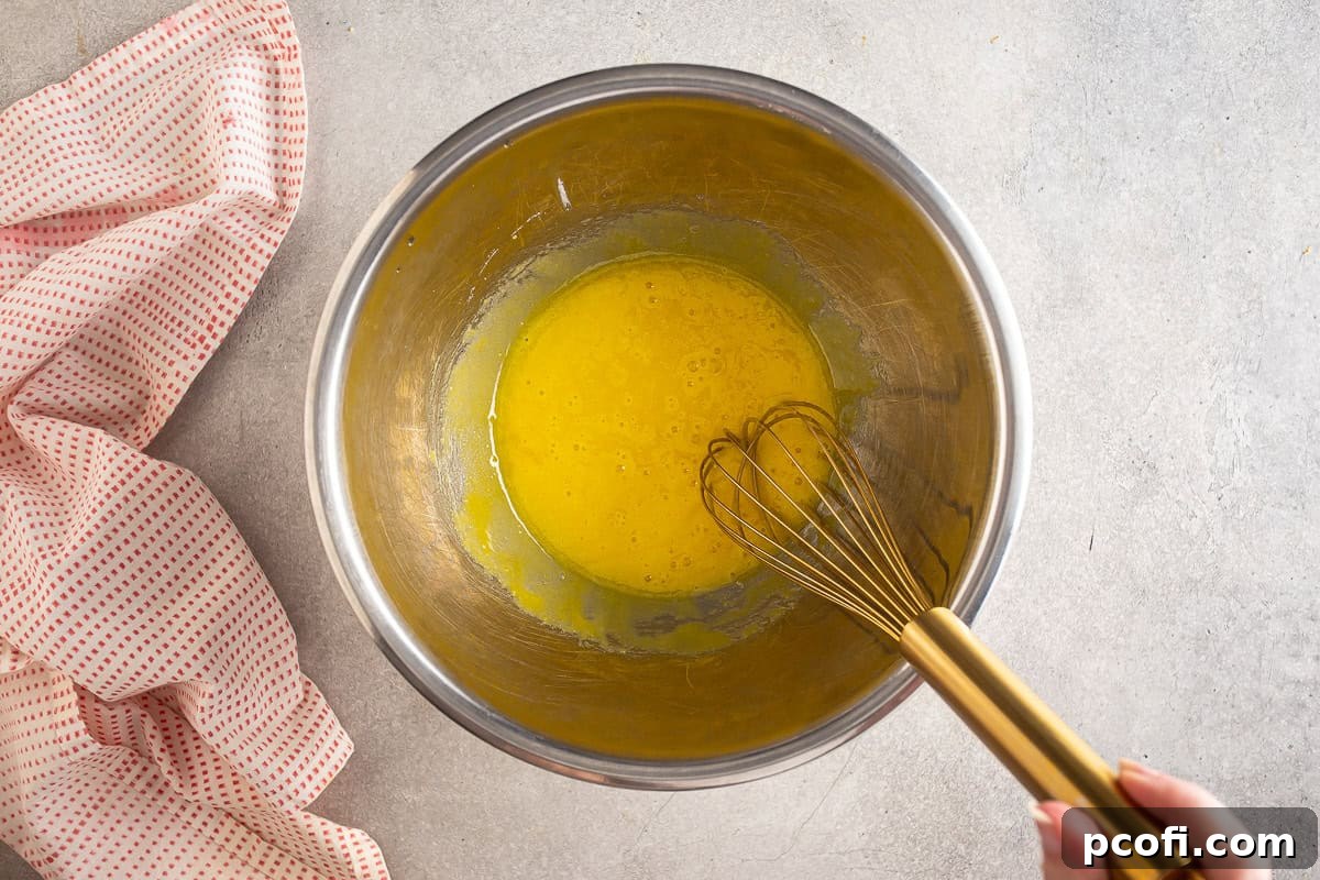 Strawberry Tiramisu Recipe with Mascarpone and Ladyfingers 4 Uncooked egg yolks in a metal bowl.
