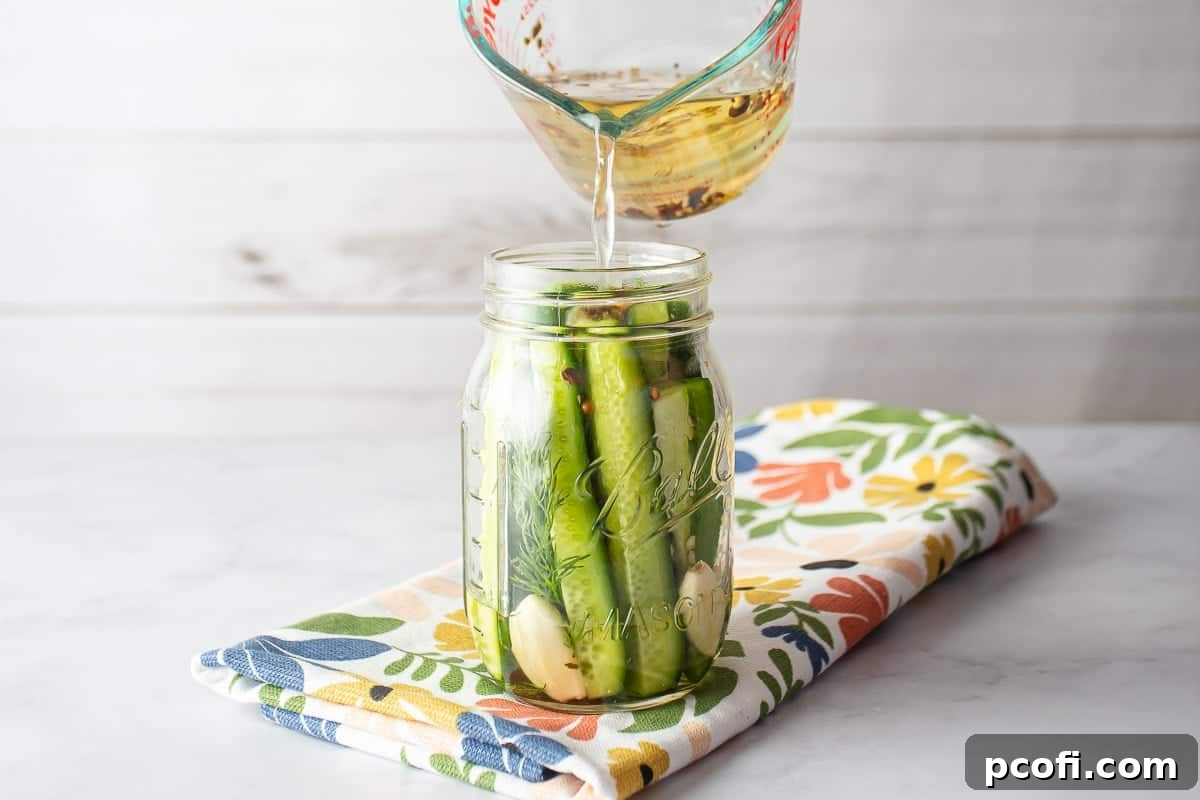 Homemade Dill Pickles: Crispy Refrigerator and Canning Recipes 7 Pouring bring into the jar of pickles.